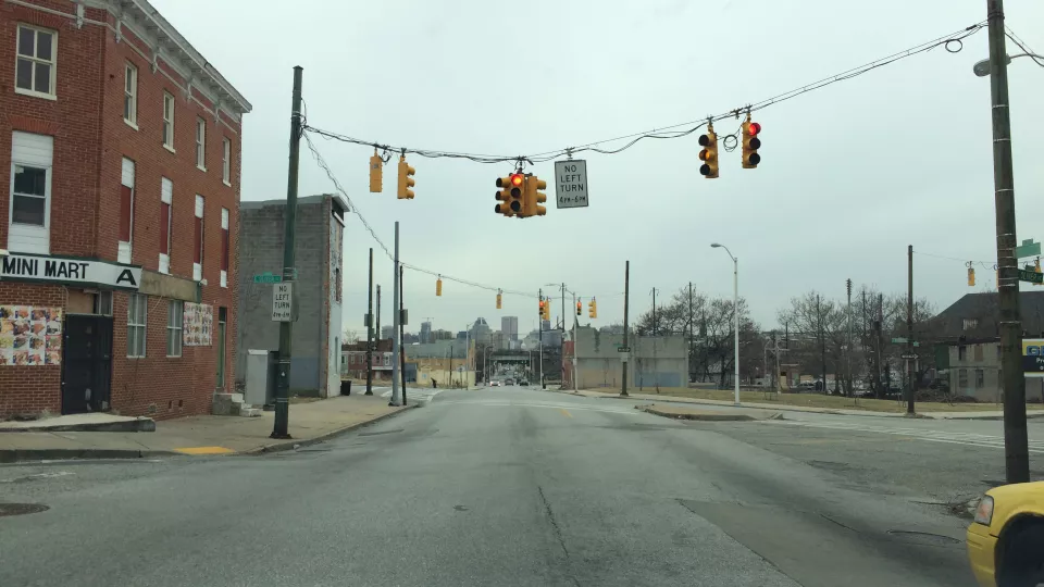 Gatubild från staden Baltimore i USA. Bilden visar en tom gata med trafikljus hängande över vägen. Foto.