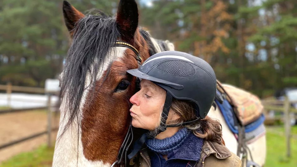 Kvinna pussar en häst.