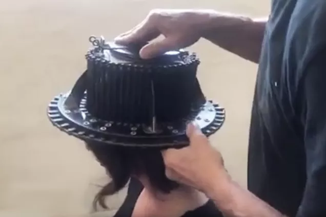 hattmakare tar huvudmått inför tillverkning av doktorshatt