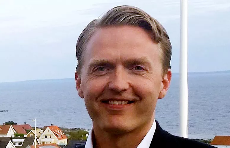 Håkan Jankensgård. Porträttfoto. Havet skymtar i bakgrunden.