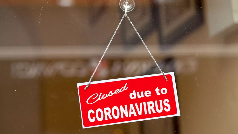 Röd skylt med texten: Closed, due to Coronavirus. Foto.