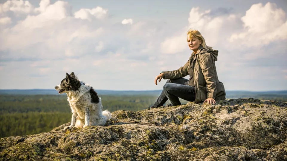 En hund och en kvinna sitter på ett berg 