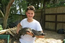 Stephan Reber håller en liten alligator i famnen