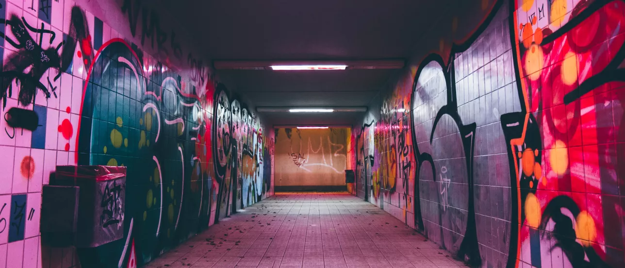 En tunnel med graffiti på väggarna. Foto.