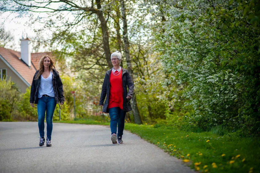Frida Eek och Eva Ekvall Hansson promenerar på en gångväg utomhus.